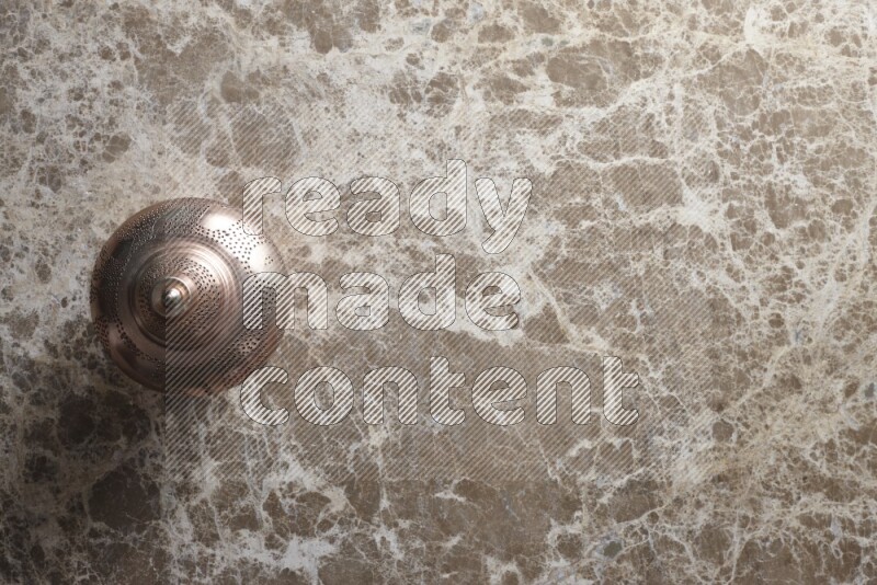 A lantern placed on a beige marble background