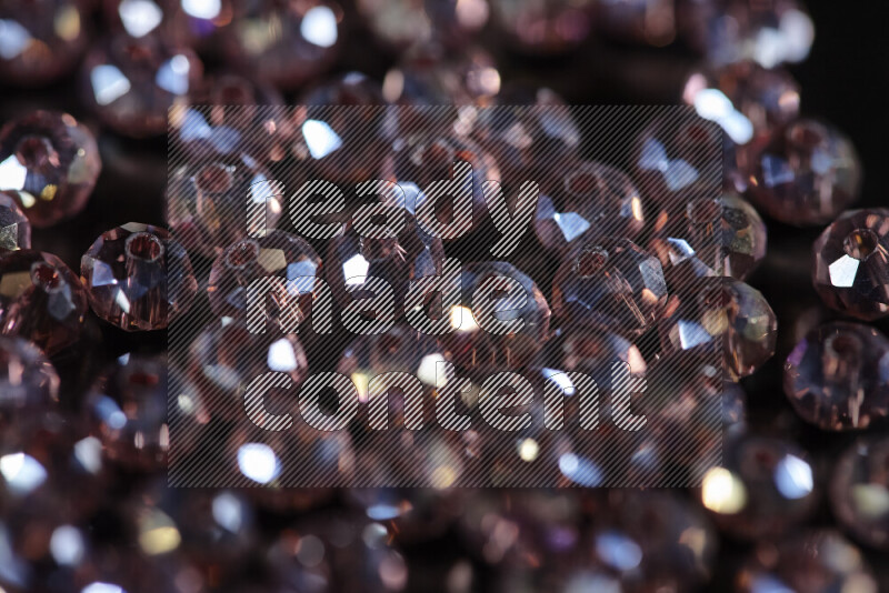Rose transparent crystal beads scattered on a black background