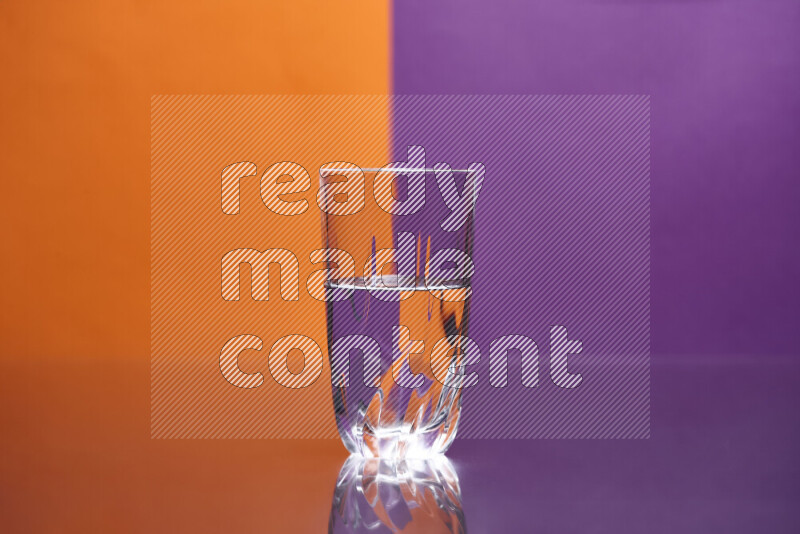 The image features a clear glassware filled with water, set against orange and purple background