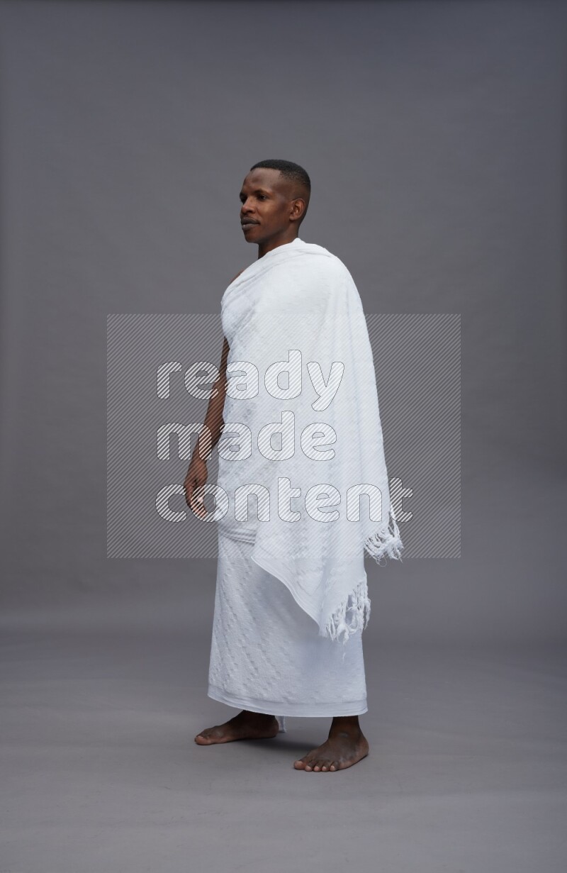 A man wearing Ehram Standing Interacting with the camera on gray background