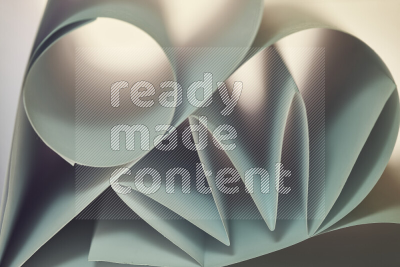 An artistic display of paper folds creating a harmonious blend of geometric shapes, highlighted by soft lighting in green and warm tones