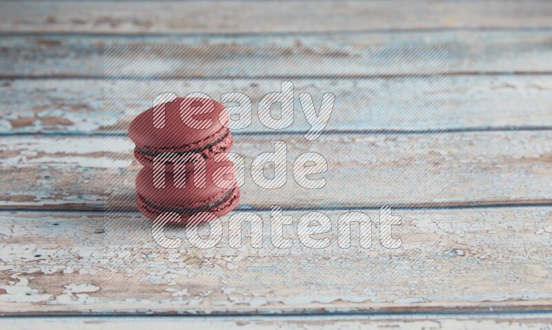 45º Shot of two Red Cherry macarons on light blue wooden background