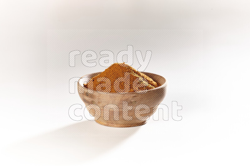 A wooden bowl full of ground paprika powder on white background