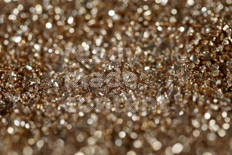 Gold shimmering fragments of glass scattered on a black background