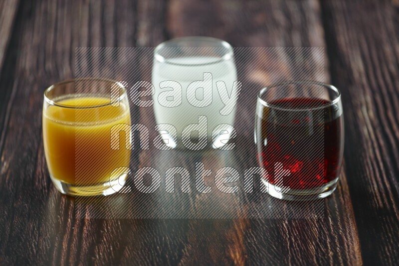 Cold drinks in a glass cup such as water, tamarind, qamar eldin, sobia, milk and hibiscus on wooden background