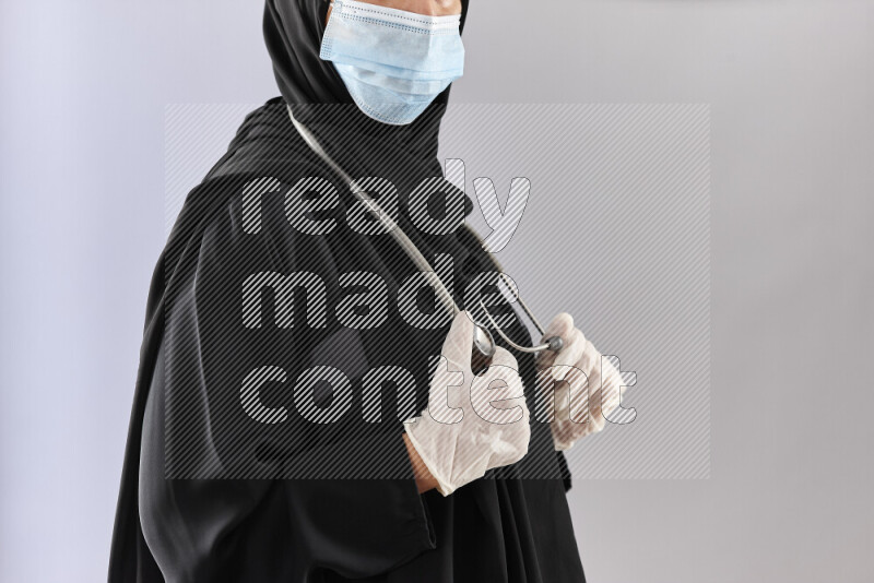 Female doctor wearing an abaya and medical attire in different positions