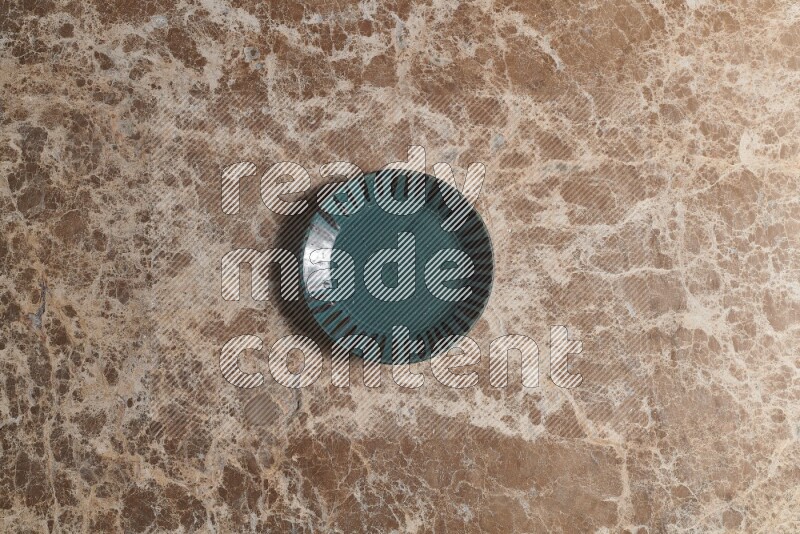 A multicolored pottery plate on beige marble background