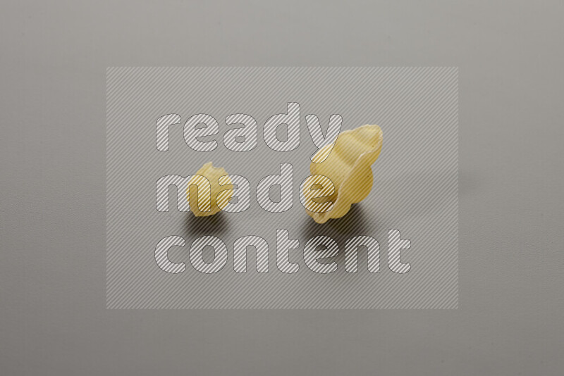 Shells pasta with other types of pasta on grey background