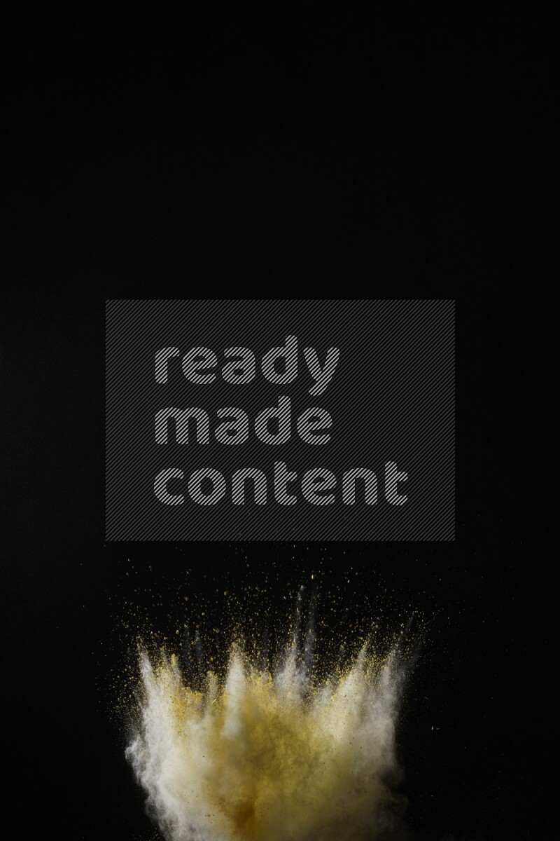 A side view of yellow powder explosion on black background