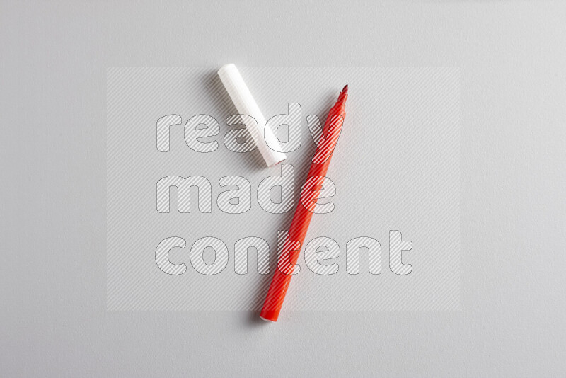 A close-up showing an open single coloring pen with a cap on grey background