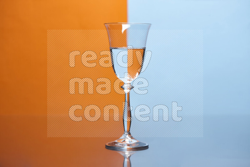 The image features a clear glassware filled with water, set against orange and light blue background