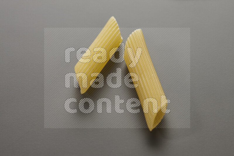 Penne pasta on grey background
