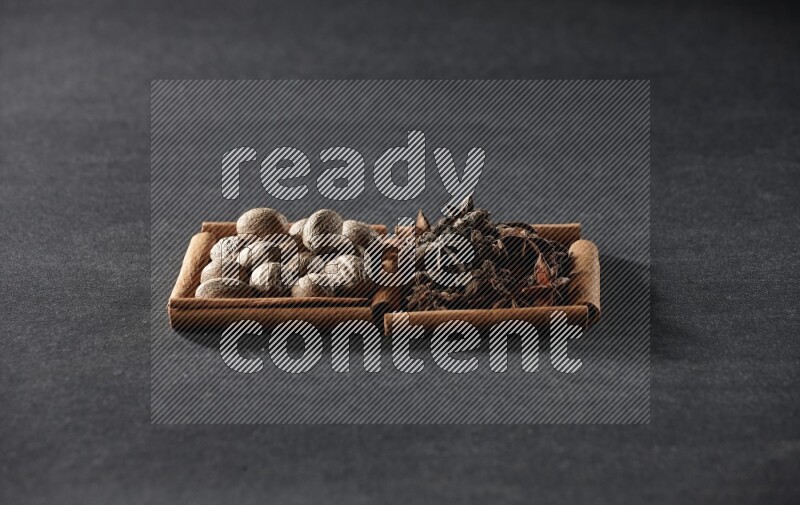 مربعان من أعواد القرفة ممتلئان بجوزة الطيب واليانسون النجمي علي خلفية سوداء