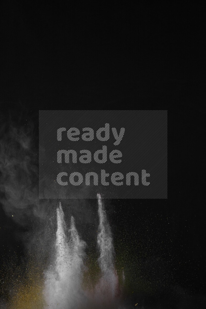 A side view of multicolored powder explosion on black background