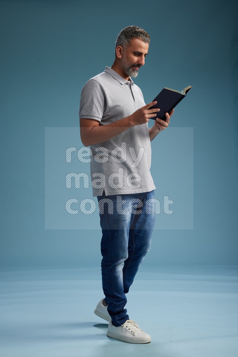 Man Standing reading book on blue background