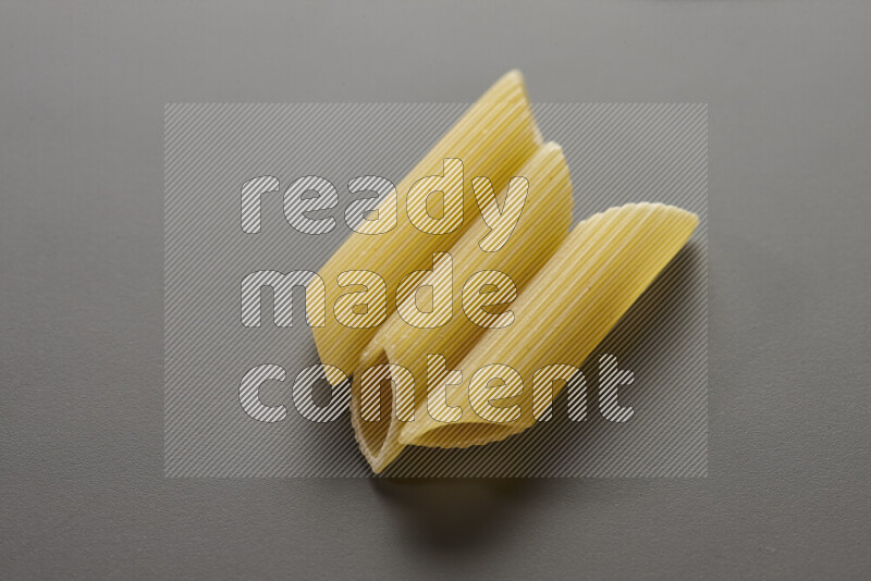 Penne pasta on grey background