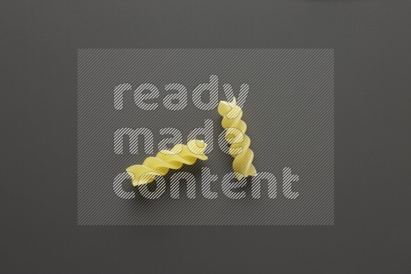 Fusilli pasta on grey background