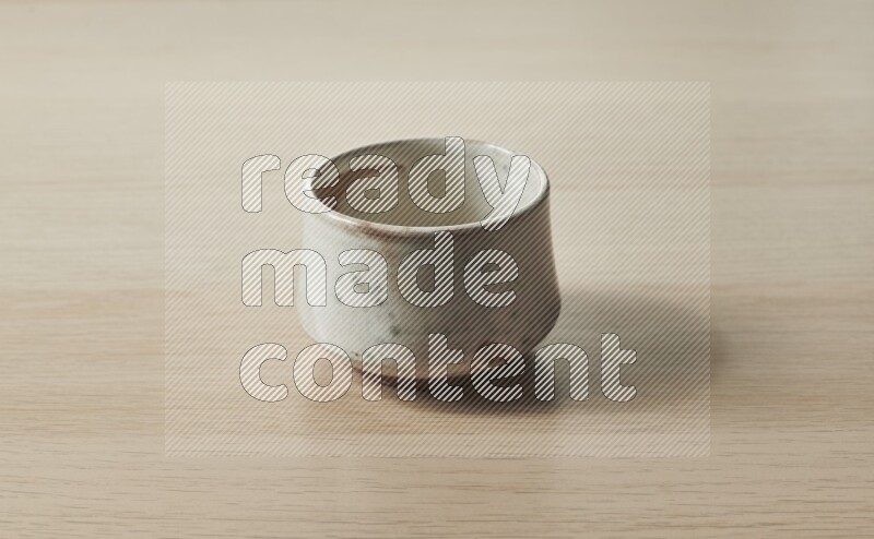 وعاء فخاري بيج على خلفية خشبية فاتحة