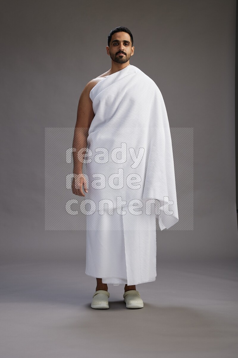 A man wearing Ehram Standing Interacting with the camera on gray background
