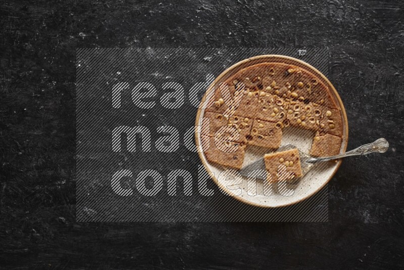 بسبوسة في أطباق مختلفه علي خلفية سوداء خشبية