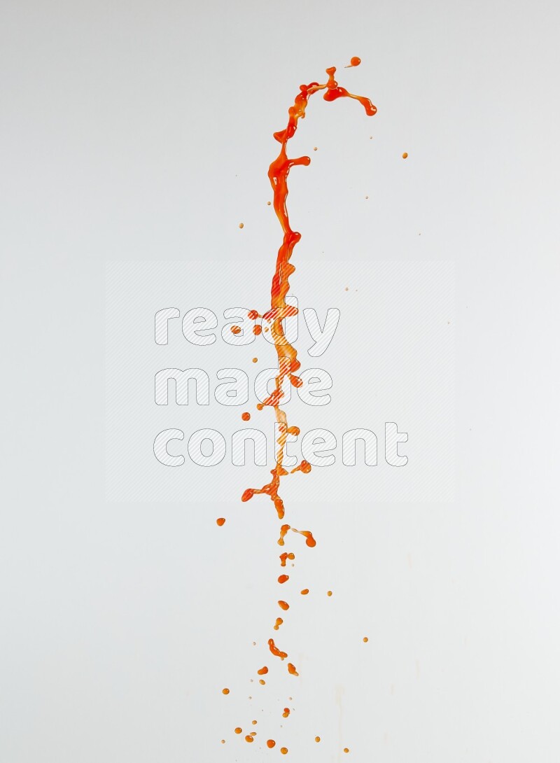 Orange liquid splash and drops on white background