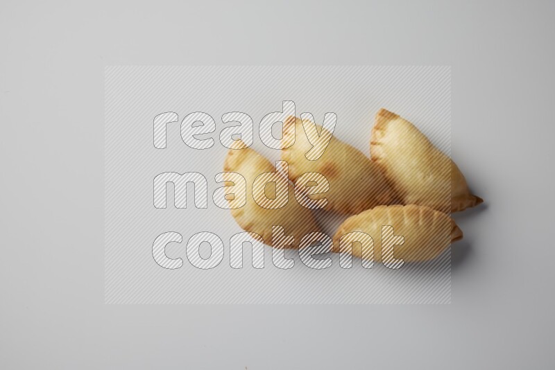Four fried sambosa from a top angle on a white background