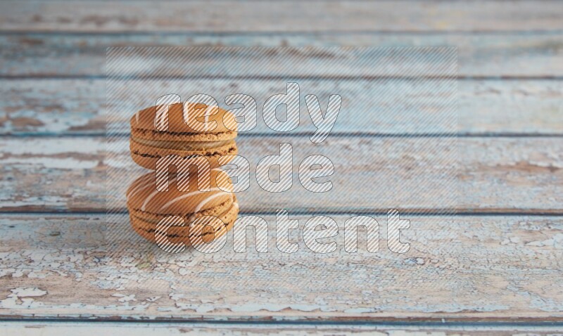 45º Shot of two Brown Irish Cream macarons on a  light blue wooden background