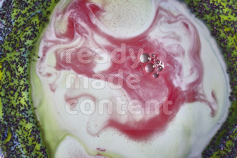 لقطة مقربة لدوامات من اللون الأحمر والأبيض مع بريق أرجواني متلألئ منتشر على خلفية من اللون الأخضر والأزرق