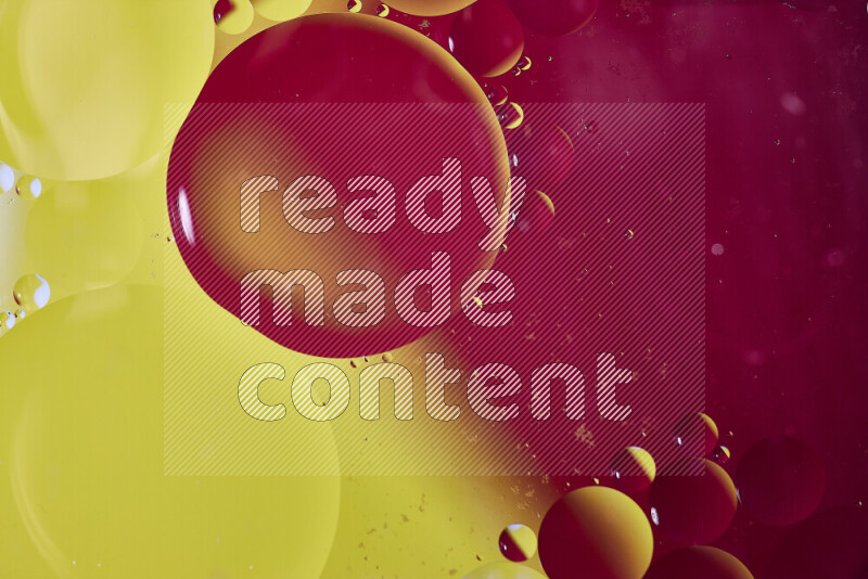 لقطات مقربة لفقاعات من الزيت على سطح الماء باللون الأصفر والوردي