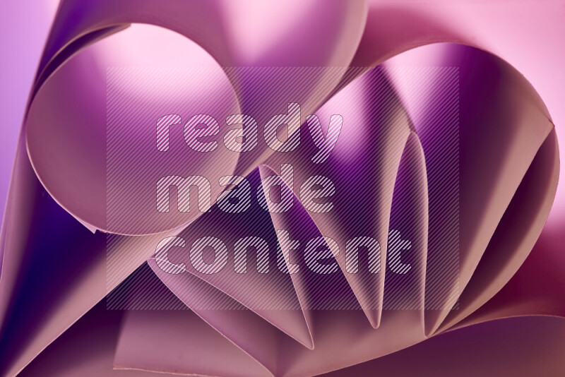 An artistic display of paper folds creating a harmonious blend of geometric shapes, highlighted by soft lighting in purple tones