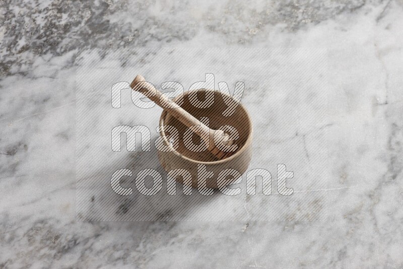 Multicolored pottery bowl with wooden honey dipper in it on grey marble background