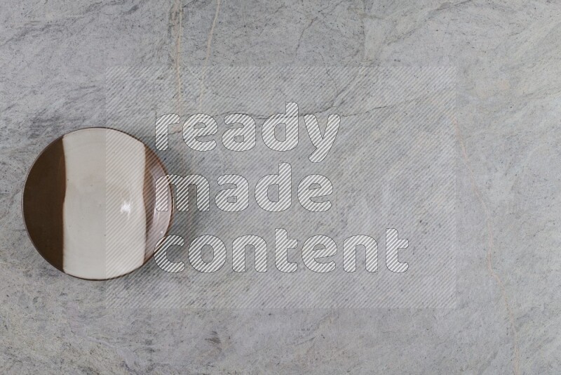 A multicolored pottery plate on grey marble background