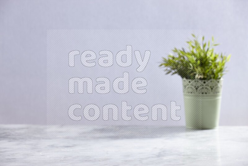 Artificial plant in green decorative pot on grey marble background