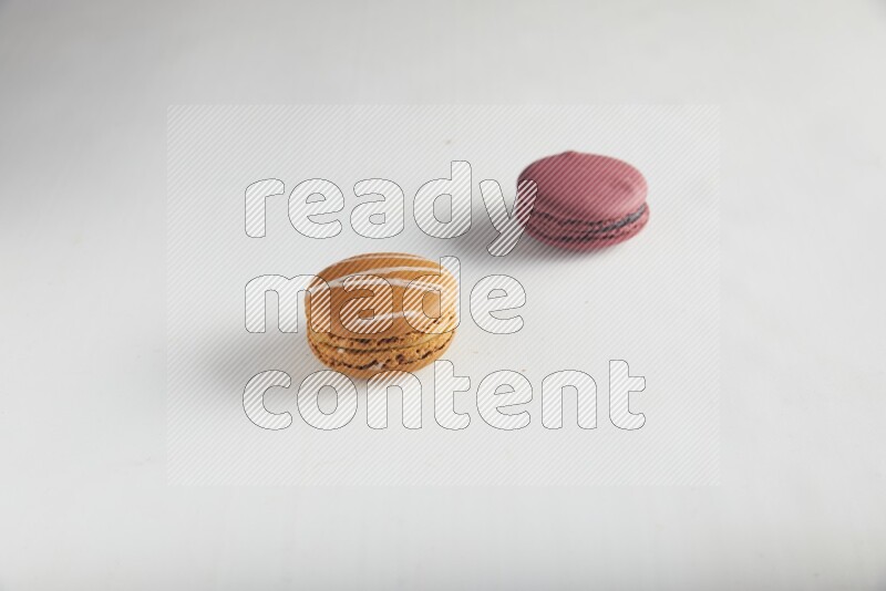 45º Shot of of two assorted Brown Irish Cream, and Red Cherry macarons on white background