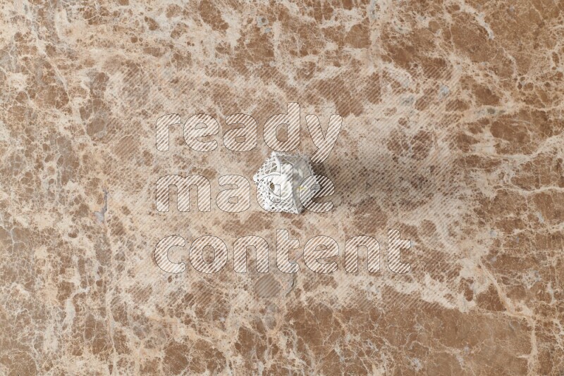 A candle lantern on beige marble background