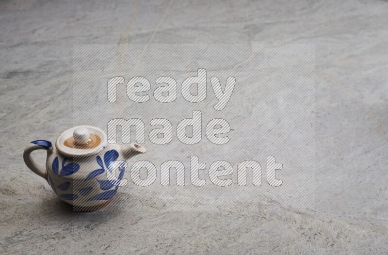 A pottery teapot on grey marble background