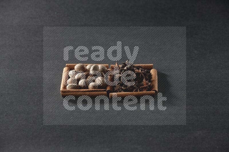 مربعان من أعواد القرفة ممتلئان بجوزة الطيب واليانسون النجمي علي خلفية سوداء