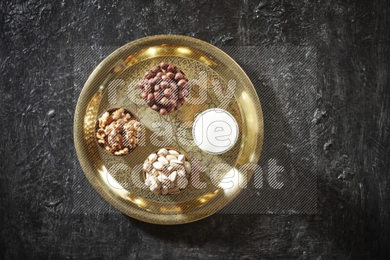 Nuts in metal bowls with sobya on a tray in dark setup