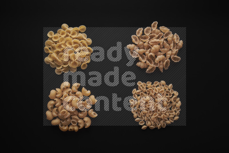Different pasta types in bunches on black background