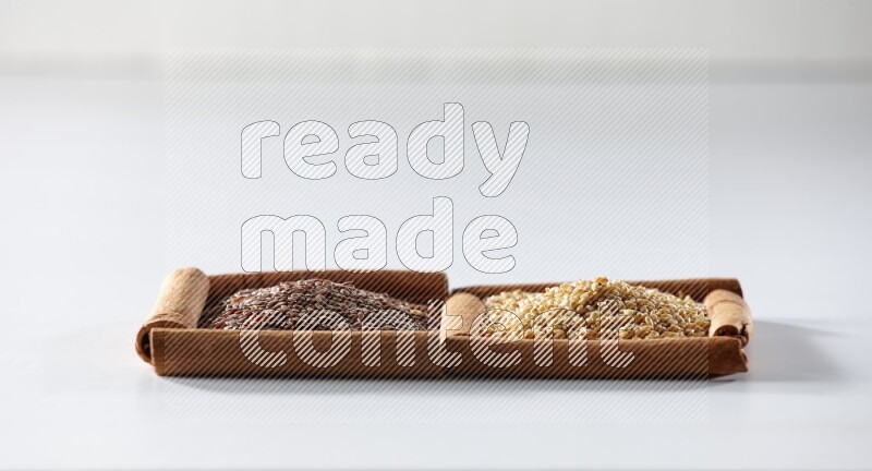 2 squares of cinnamon sticks full of flaxseeds and sesame on white flooring