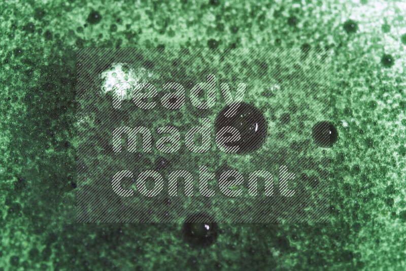 Close-ups of abstract green watercolor drops on oil Surface on white background