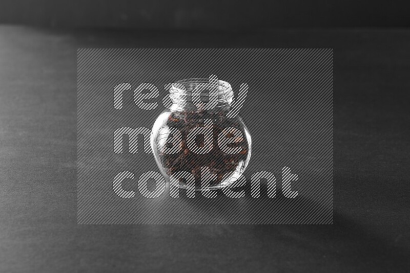 قرنفل في وعاء زجاجي علي خلفية سوداء