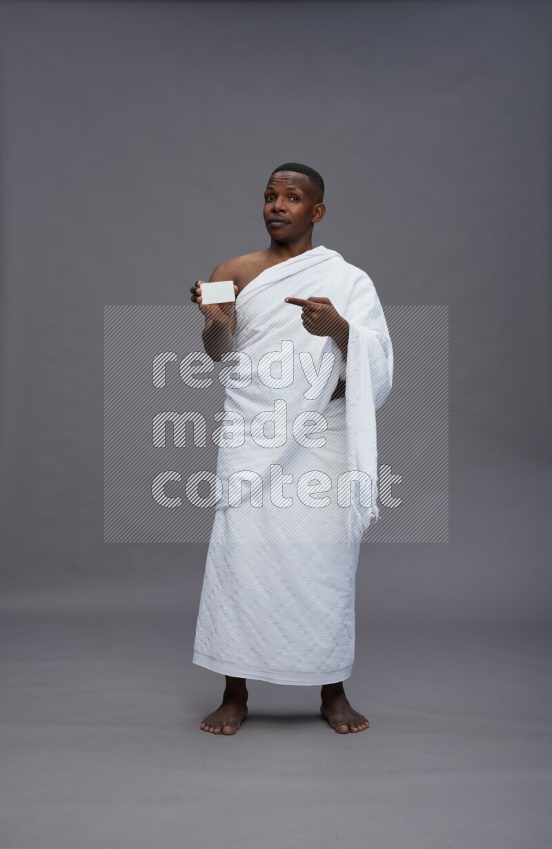 A man wearing Ehram Standing holding ATM card on gray background