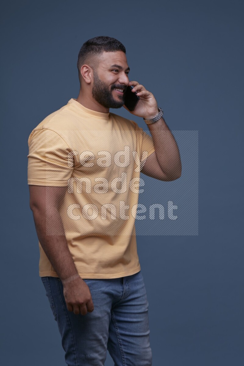 A man Calling on Blue Background wearing Orange T-shirt