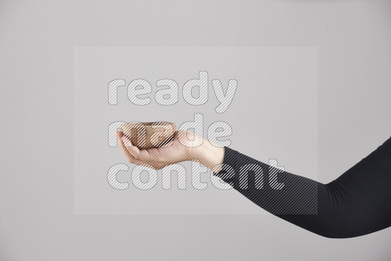 امرأة ترتدي عباءة سوداء تحمل أدوات خشبية مختلفة في أوضاع متعددة