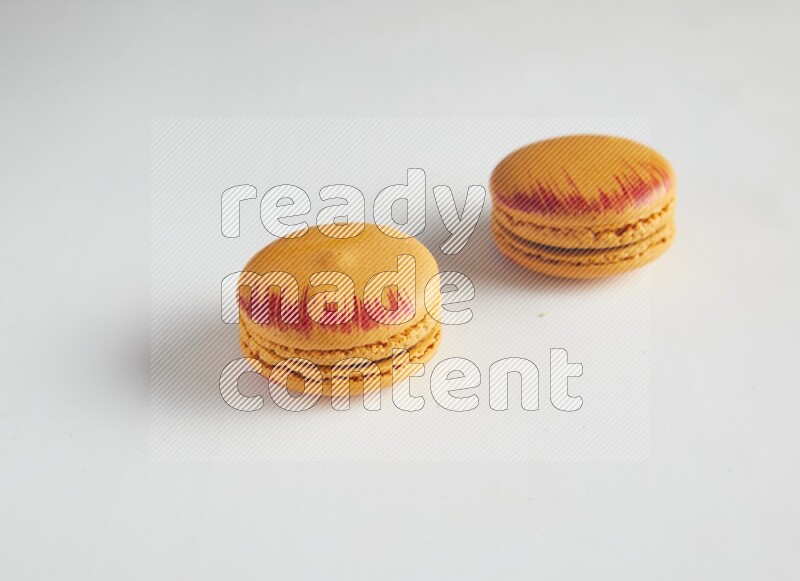 45º Shot of two orange Exotic macarons on white background