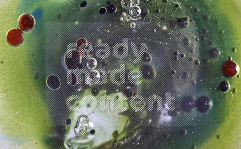 لقطات مقربة لقطرات ألوان مائية حمراء وخضراء وزرقاء على سطح الزيت على خلفية خضراء