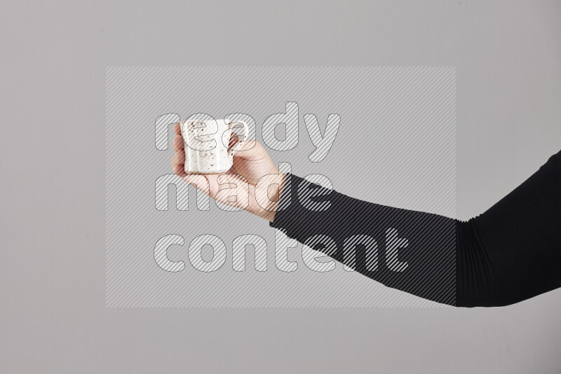 امرأة ترتدي عباءة سوداء تحمل أدوات فخارية مختلفة في أوضاع متعددة