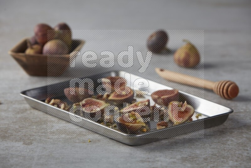 fresh figs on an oven tray on a textured grey background