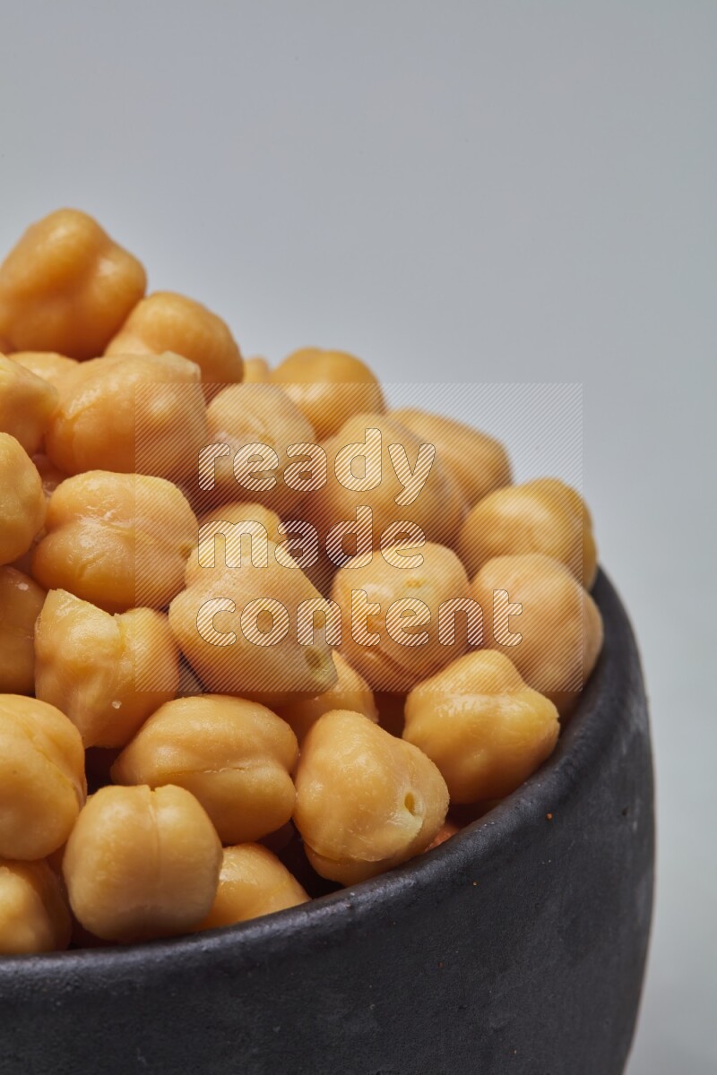 Close up of a boiled chickpeas in a container on white background